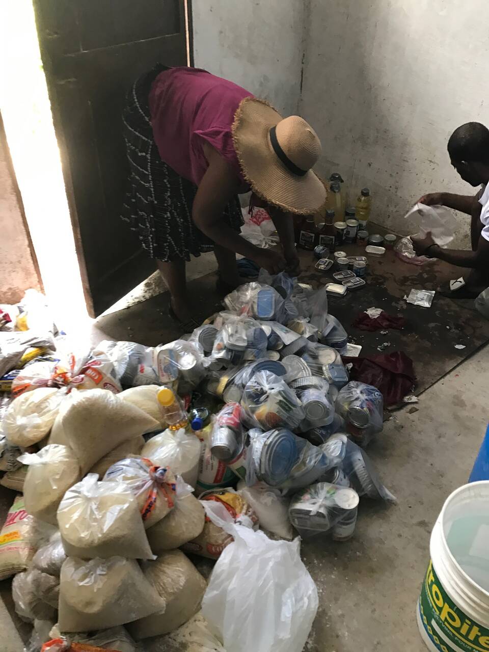 Sorting bags of rice, cans, and oil for distribution