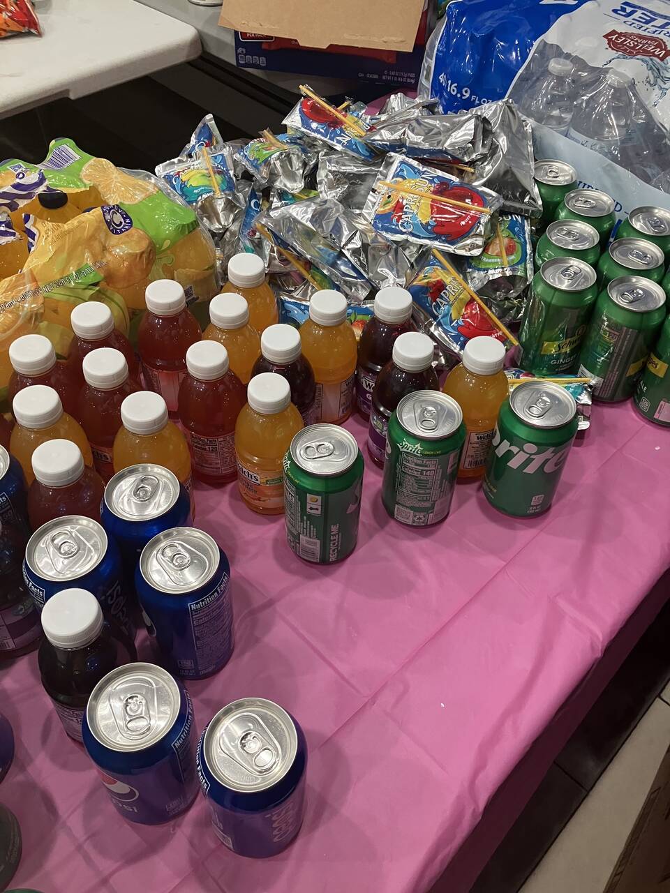 Beverage table arranged with a rainbow of drinks for shelter families